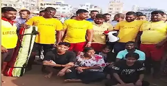 Lifeguards rescuing tourists from strong waves at Swargadwar beach in Puri